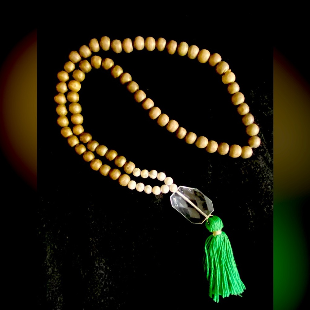 Fun beaded necklace with clear bead and a green tassel.